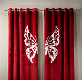 Red curtains with white butterfly designs on a beige wall