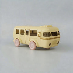 Yellow toy bus with pink wheels on a gray background