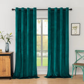Teal curtains hanging in a room with a window, wooden cabinet, and chair.