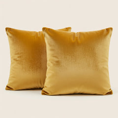 Two mustard yellow pillows on a light beige background