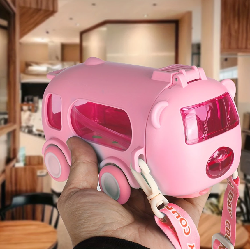 Pink toy car with a pig design held by a hand in an indoor setting