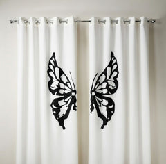 White curtains with black butterfly designs on a neutral background