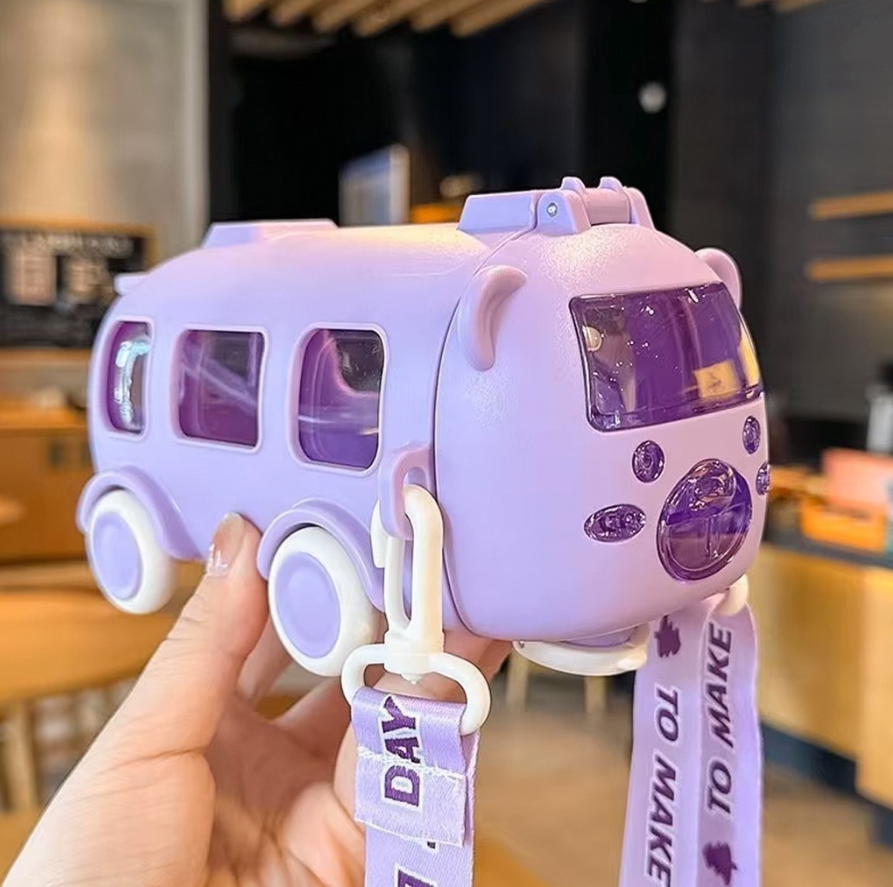 Purple toy bus with a ribbon held by a hand in an indoor setting