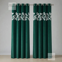 Pair of green curtains with white floral patterns on a gray background