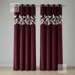 Pair of maroon curtains with white floral patterns on a gray background