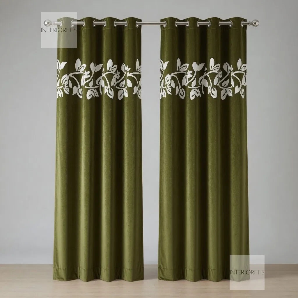 Pair of olive curtains with white floral embroidery on a gray background