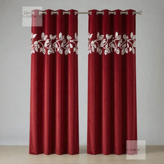 Red curtains with white floral patterns on a plain background