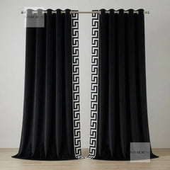 Black curtains with white geometric pattern on a wooden floor and light gray wall background.