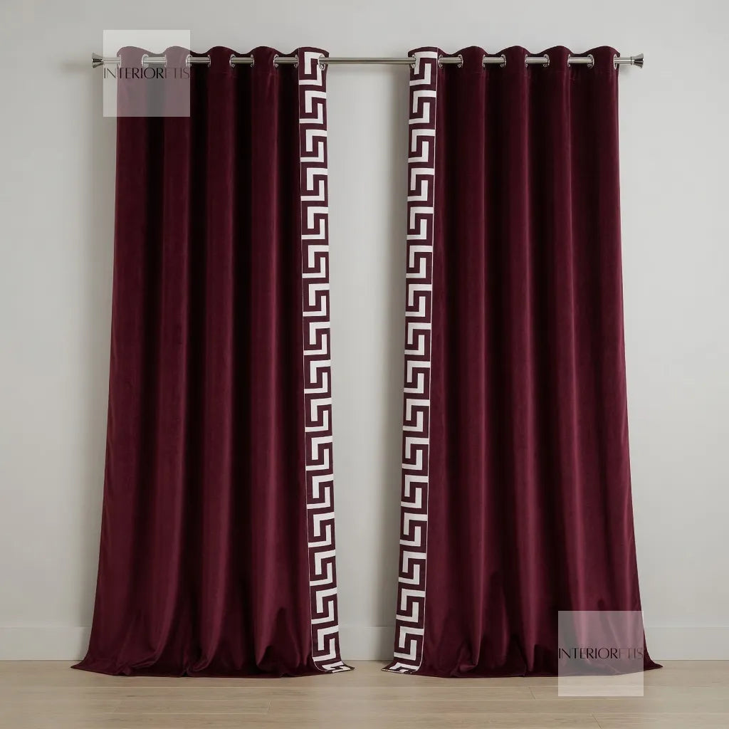 Maroon curtains with a white geometric pattern on a plain background