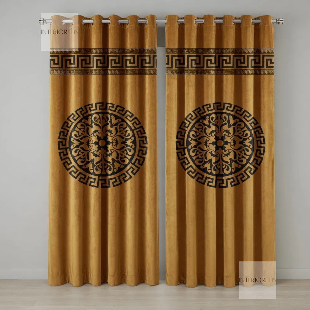 Pair of gold curtains with decorative black patterns on a plain background