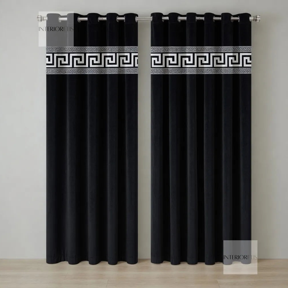 Pair of black curtains with decorative white banding on a neutral background