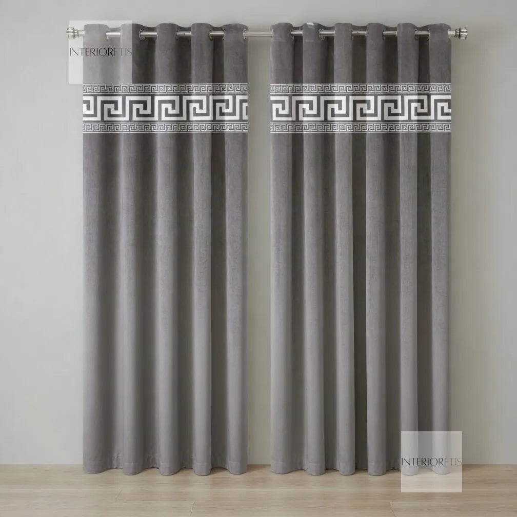 Pair of gray curtains with decorative banding on a plain background