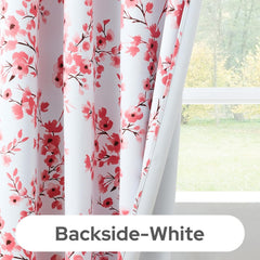 Floral patterned curtains with a white backside, hanging in front of a window.