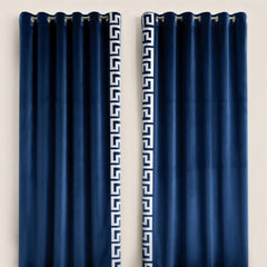 Pair of navy blue curtains with decorative white patterns on a beige background