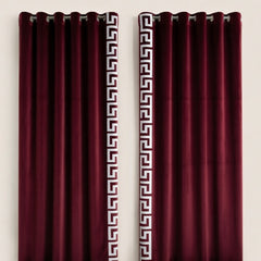 Pair of burgundy curtains with Greek key pattern on a white background