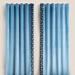 Pair of blue curtains with decorative patterns on a beige background