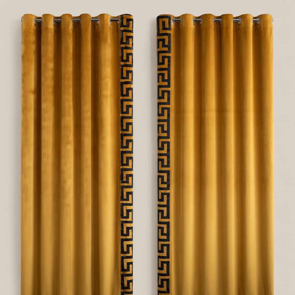 Pair of mustard yellow curtains with decorative black patterns on a beige background