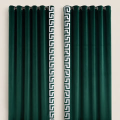 Pair of green curtains with decorative white patterns on a beige background