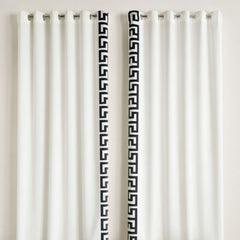 White curtains with black geometric patterns on a plain background
