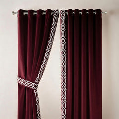Burgundy curtains with white lace trim on a plain background