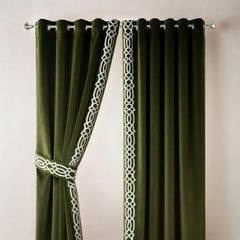 Green curtains with white geometric patterns on a plain background