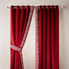 Red curtains with white geometric patterns on a plain background