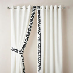 White curtains with black decorative trim on a beige background