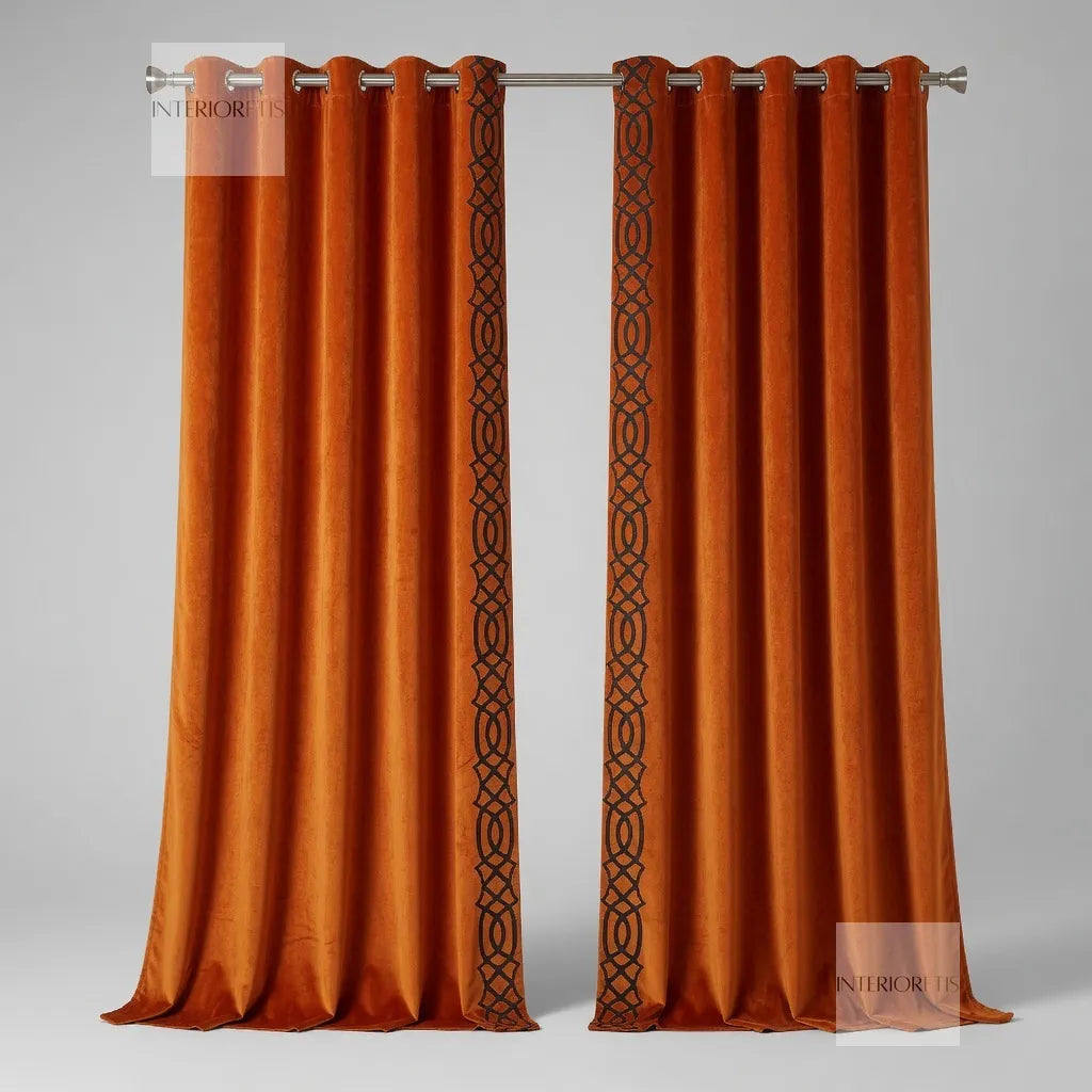 Pair of orange curtains with a decorative black pattern on a gray background