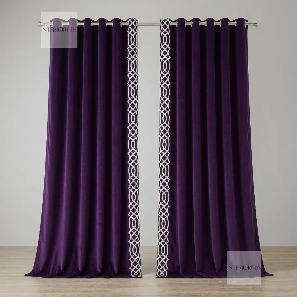 Pair of purple curtains with white geometric patterns on a wooden floor and light gray wall.