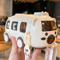 White toy van with brown accents held in a hand, blurred indoor background
