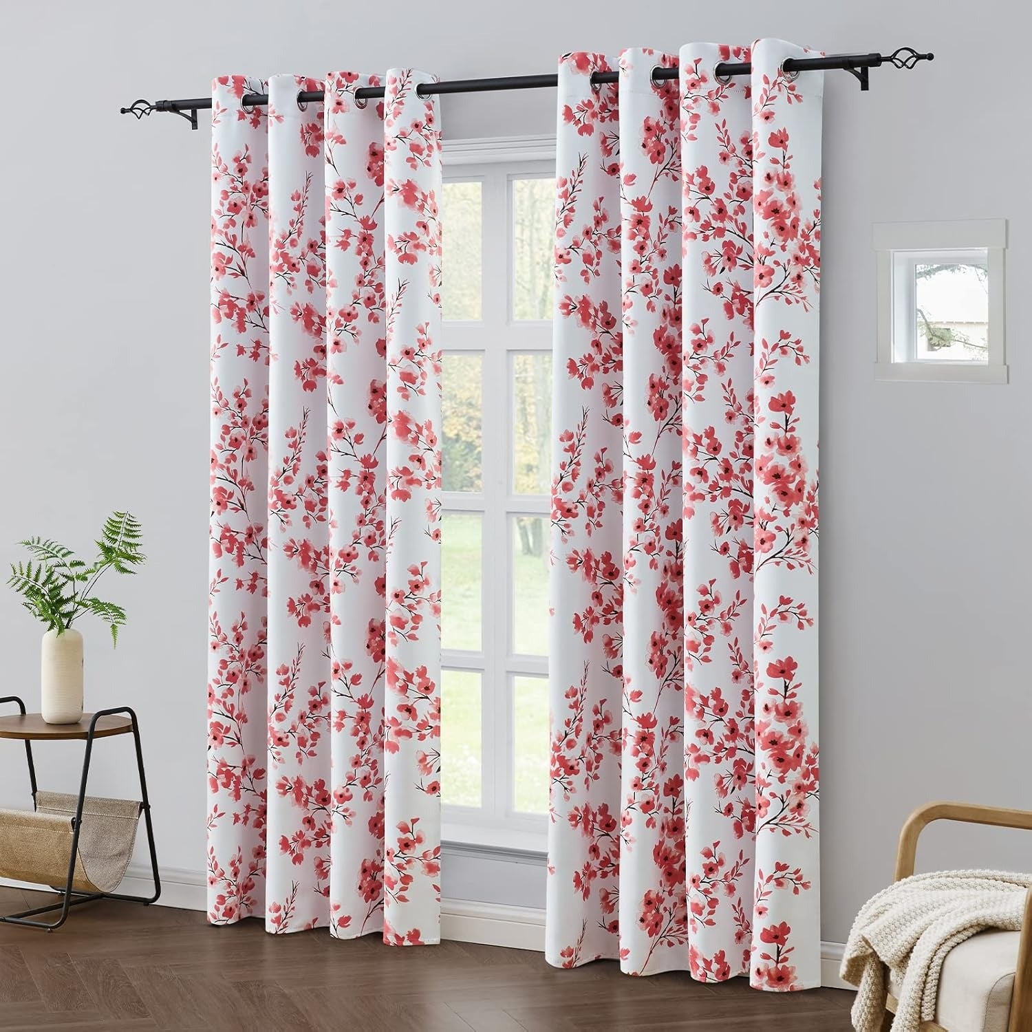 Floral patterned curtains in a room with a window and side table.