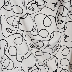 White fabric with black abstract line art designs of faces and shapes.