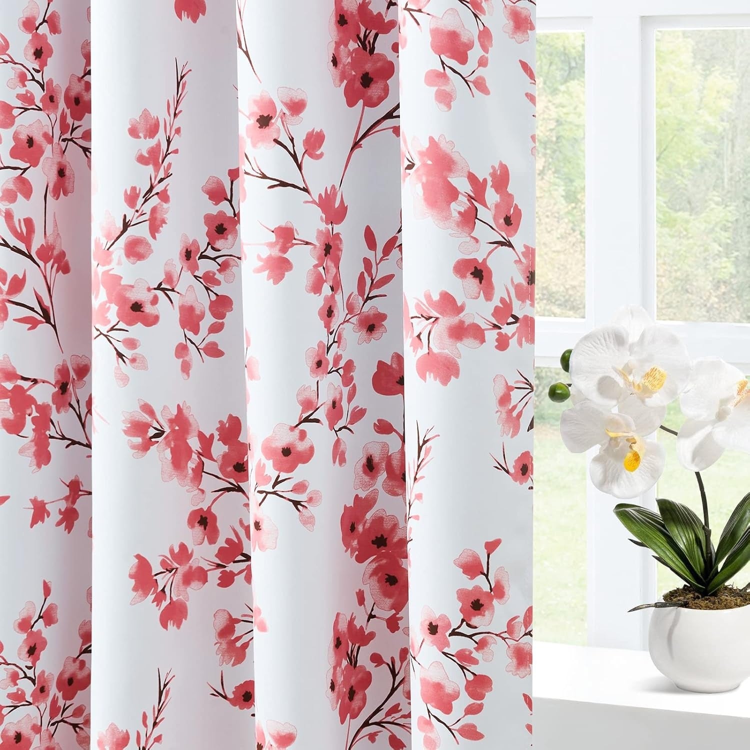 Floral patterned curtains with a window and plant in the background