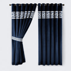 Navy blue curtains with white geometric patterns on a light gray background