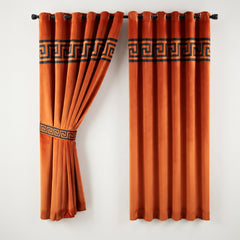 Pair of orange curtains with decorative patterns on a white background