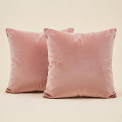 Two pink velvet pillows on a beige background